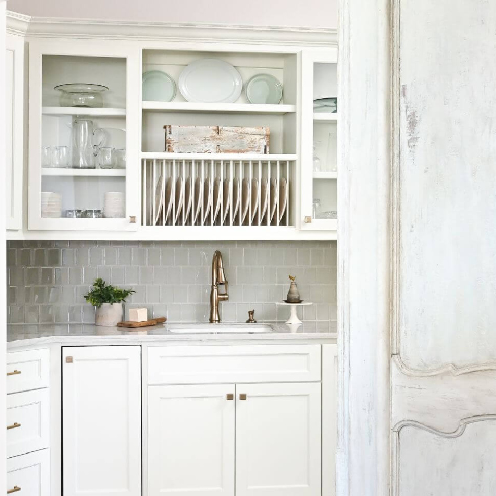 Beautiful white pantry with antiqued barn doors in a French country kitchen - Morningstar Builders. #frenchcountrypantry #frenchkitchen #pantrydesign