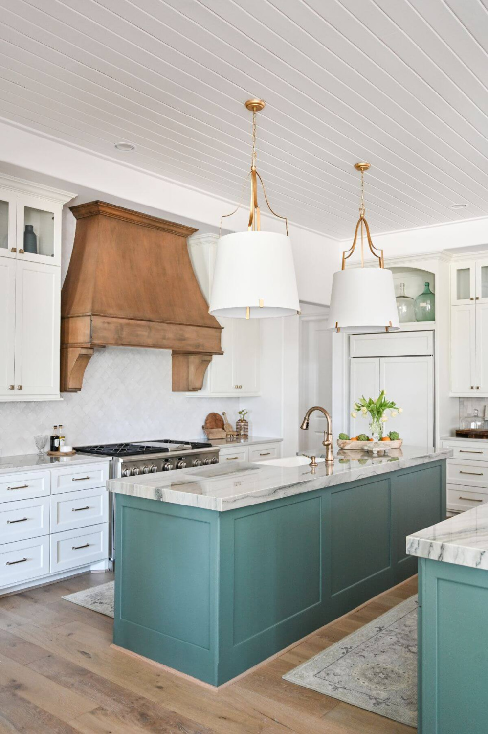 Modern French country kitchen with teal painted island, wood range hood, and paneled refrigerator - Morningstar Builders. #modernfrenchkitchen #frenchcountryinteriors