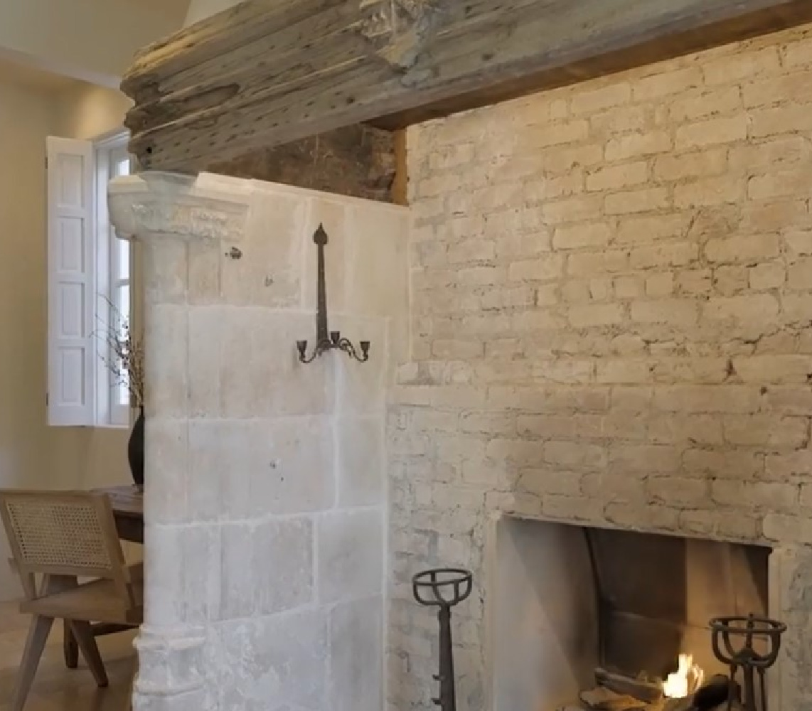 Detail of pale brick fireplace in a French Provincial style mansion. #fireplacedesign #oldworldstyle #frenchcountry