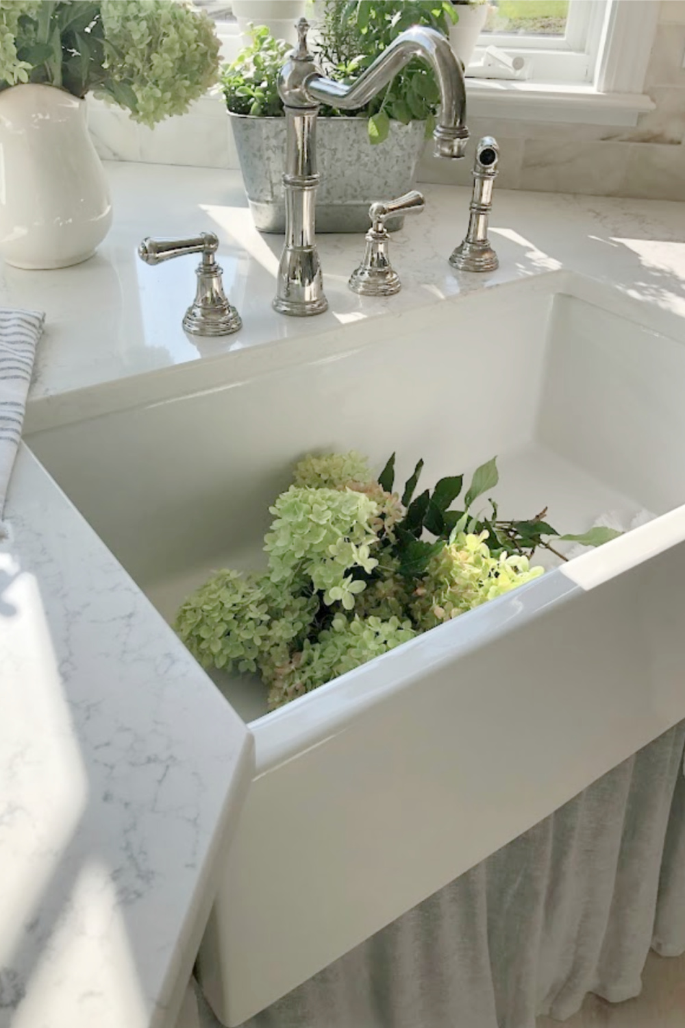 Hello Lovely's farm sink (Hyannis-30 from Nantucket Sinks) in renovated kitchen with Viatera Muse counters and Waterworks Julia faucet. #farmsinks #farmhousesink