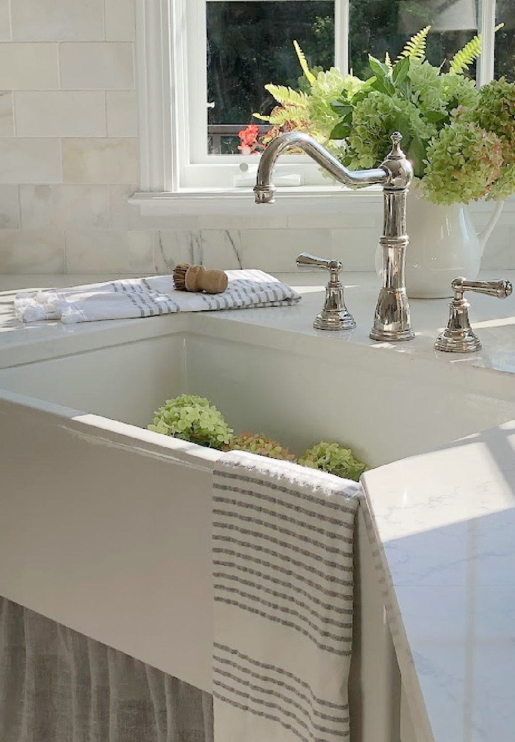 Hello Lovely's farm sink (Hyannis-30 from Nantucket Sinks) in renovated kitchen with Viatera Muse counters and Waterworks Julia faucet. #farmsinks #farmhousesink