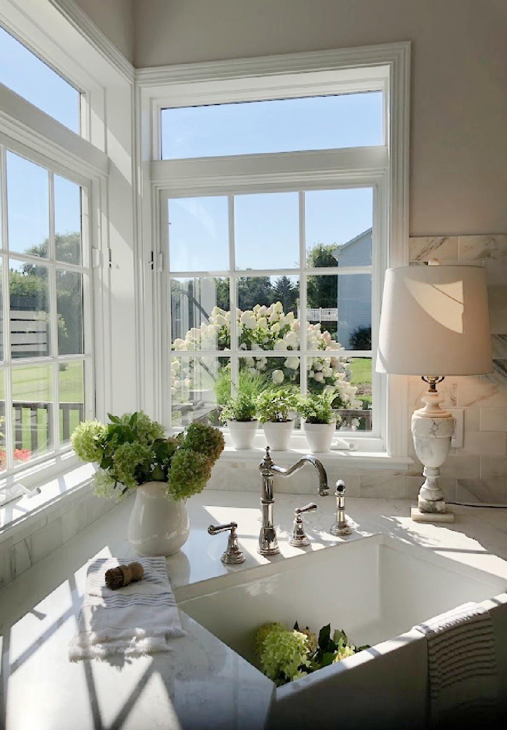 Hello Lovely's farm sink (Hyannis-30 from Nantucket Sinks) in renovated kitchen with Viatera Muse counters and Waterworks Julia faucet. #farmsinks #farmhousesink