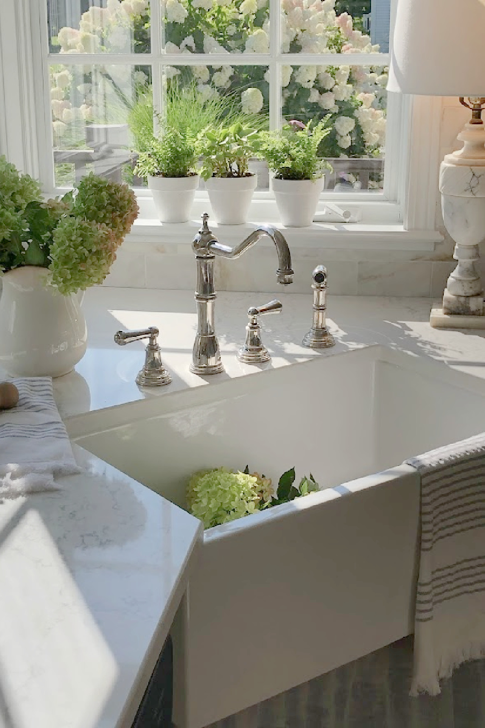 Hello Lovely's farm sink (Hyannis-30 from Nantucket Sinks) in renovated kitchen with Viatera Muse counters and Waterworks Julia faucet. #farmsinks #farmhousesink