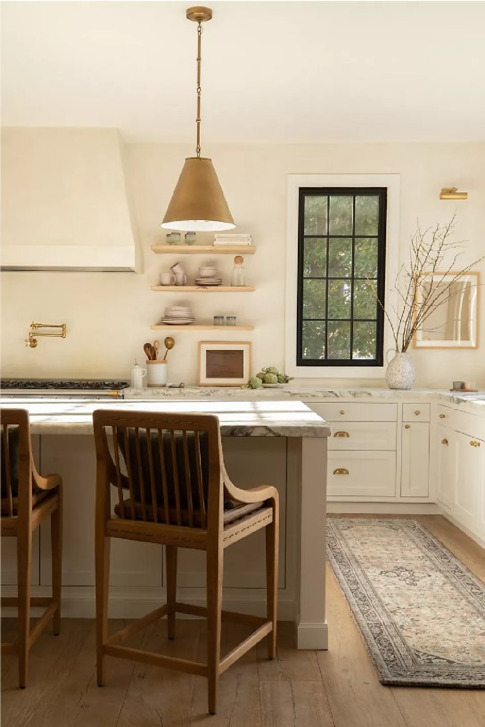 Gorgeous California laidback modern rustic luxe kitchen by Amber Lewis with Garvey Counter Stool, brass dome pendant, black window trim, and white cabinets. #modernrustic #kitchendesign #laidbackluxe