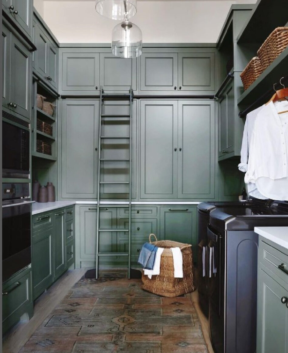 Beautiful laundry room pantry combo with green cabinets to ceiling, ladder, and impeccable design by April Tomlin Interiors. #laundryrooms #greencabinets