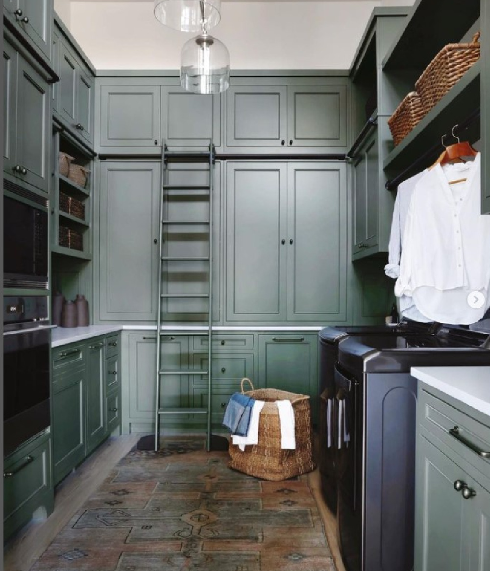 Beautiful laundry room pantry combo with green cabinets to ceiling, ladder, and impeccable design by April Tomlin Interiors. #laundryrooms #greencabinets