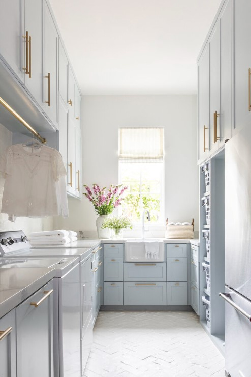 Beautiful light blue laundry room designed by Marie Flanigan. #laundryrooms #lightbluecabinets