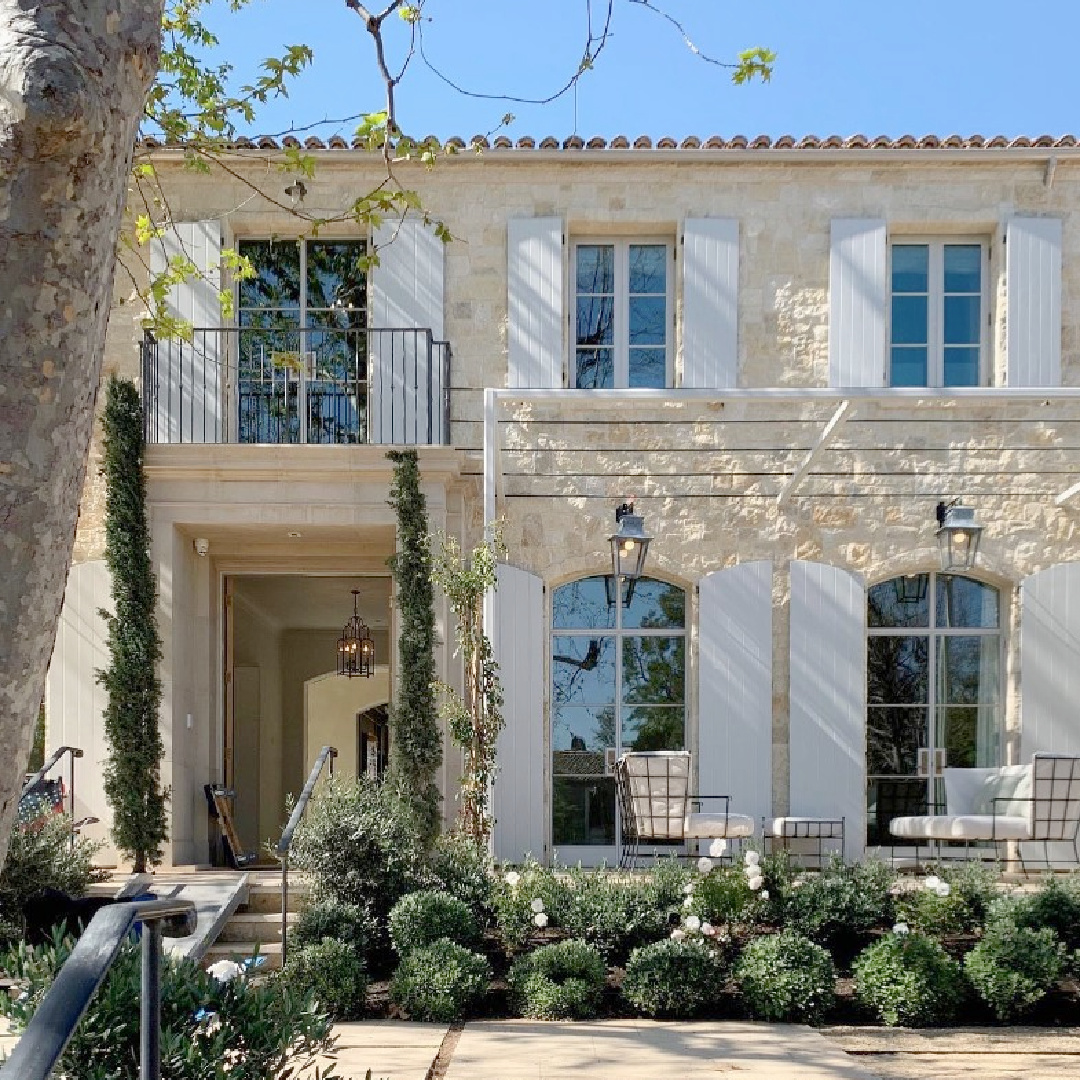 Breathtaking exterior of a French country style stone house exterior with arched windows and shutters by Giannetti Home. #modernfrench #houseexteriors