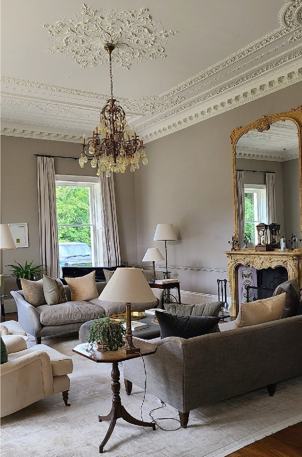 Drawing room with ornate moldings and chandelier at Heckfield Place in Hampshire, England.