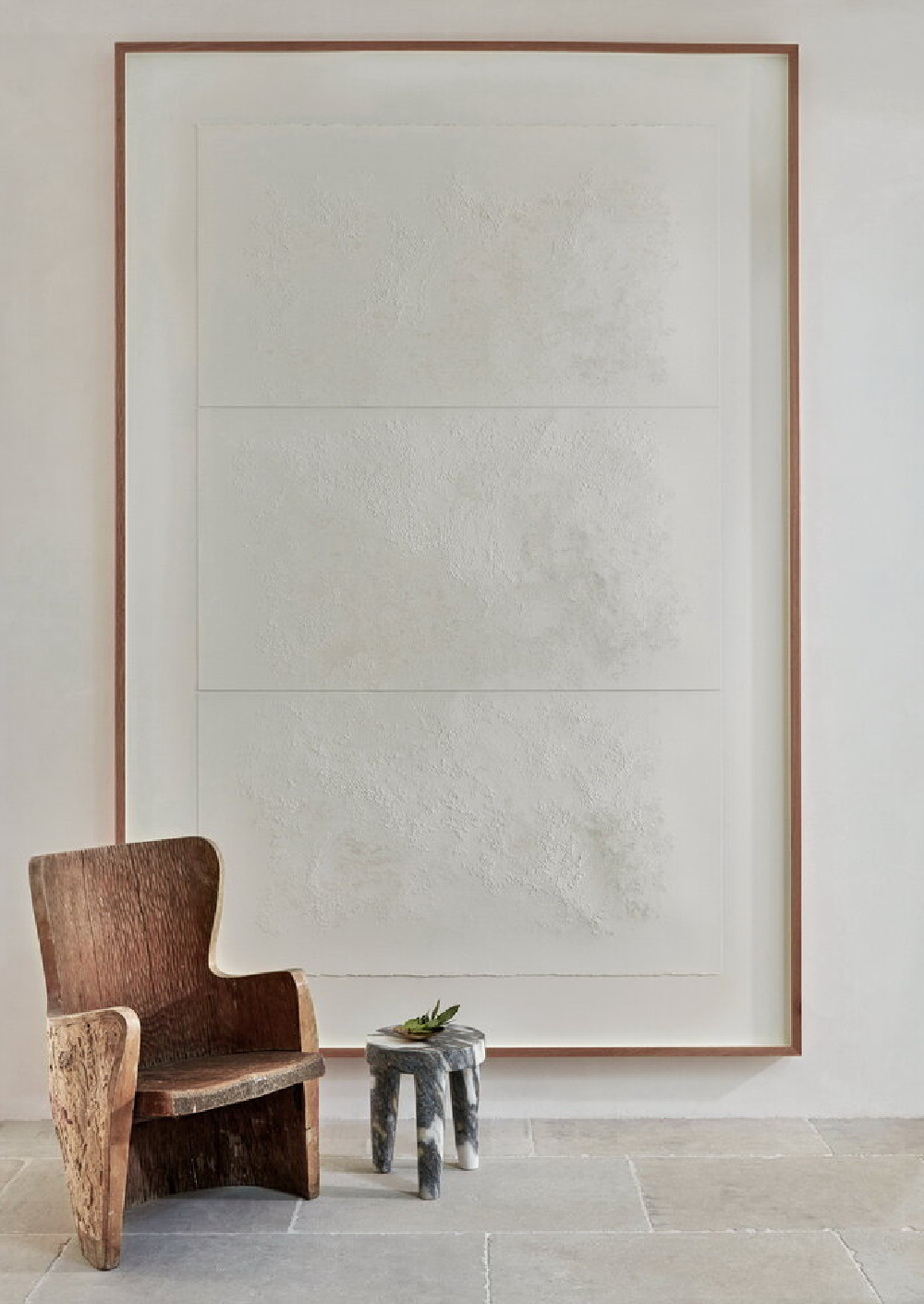 Elegant modern French entry in Jill Egan's home with antique wooden Swedish armchair, Kelly Wearstler stool, and art by Lauren Collin. #modernfrench