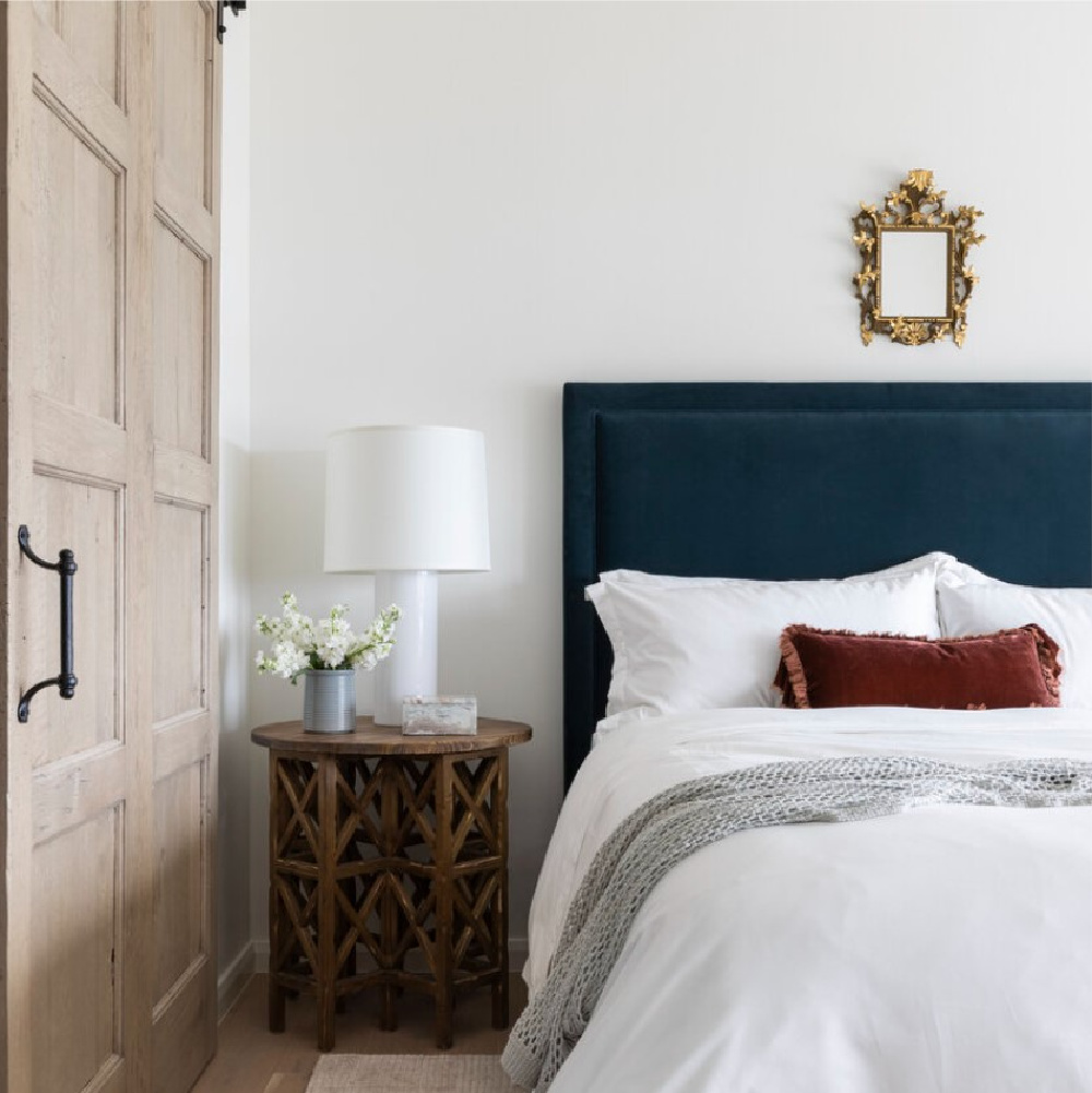 Timeless bedroom with velvet headboard and paneled door - design by Marie Flanigan. #timelessbedrooms