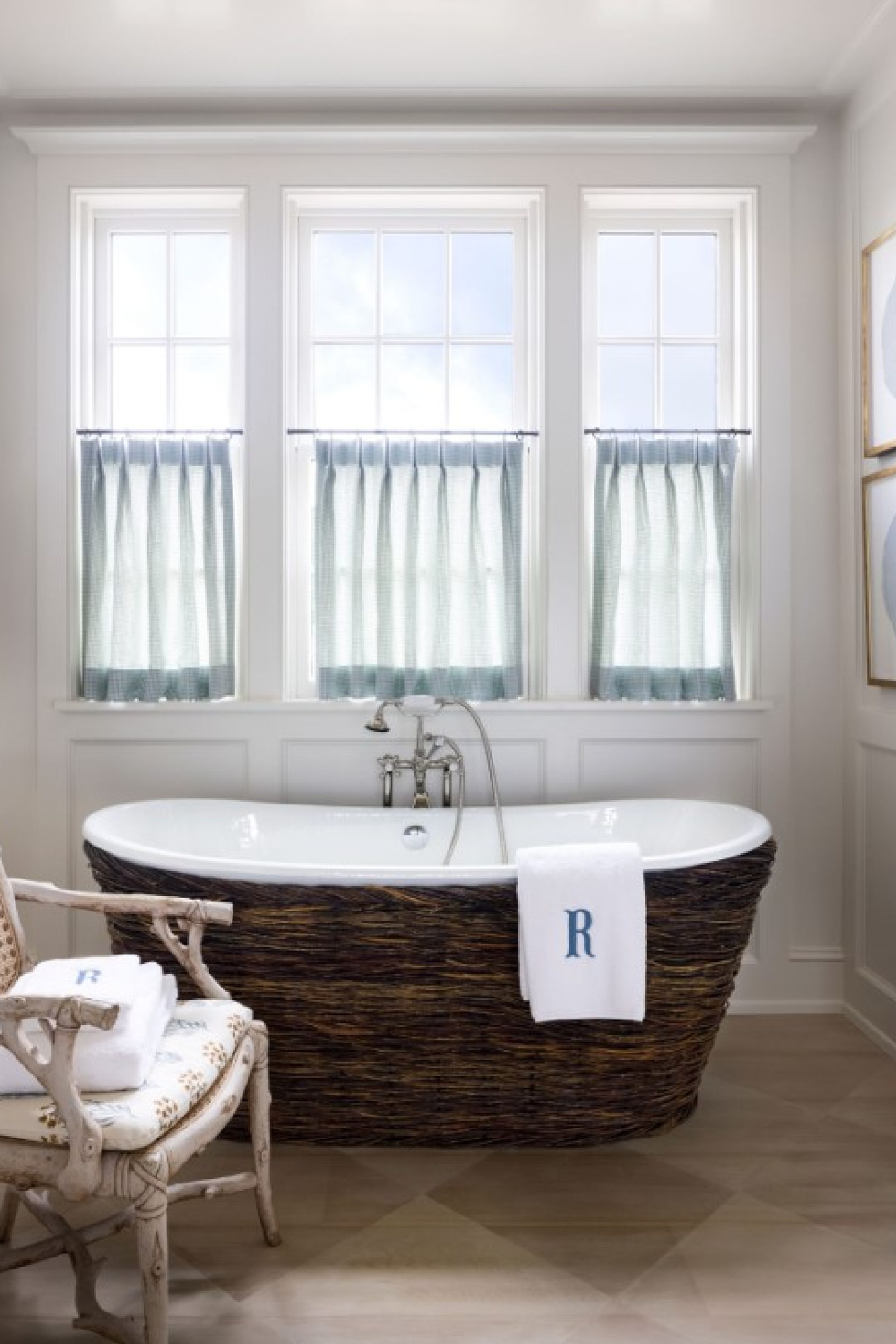 Southern Living Idea House 2021 Main Bathroom with rattan soaking tub surround and handpainted wood floor. #coastalbathroom #soakingtubs