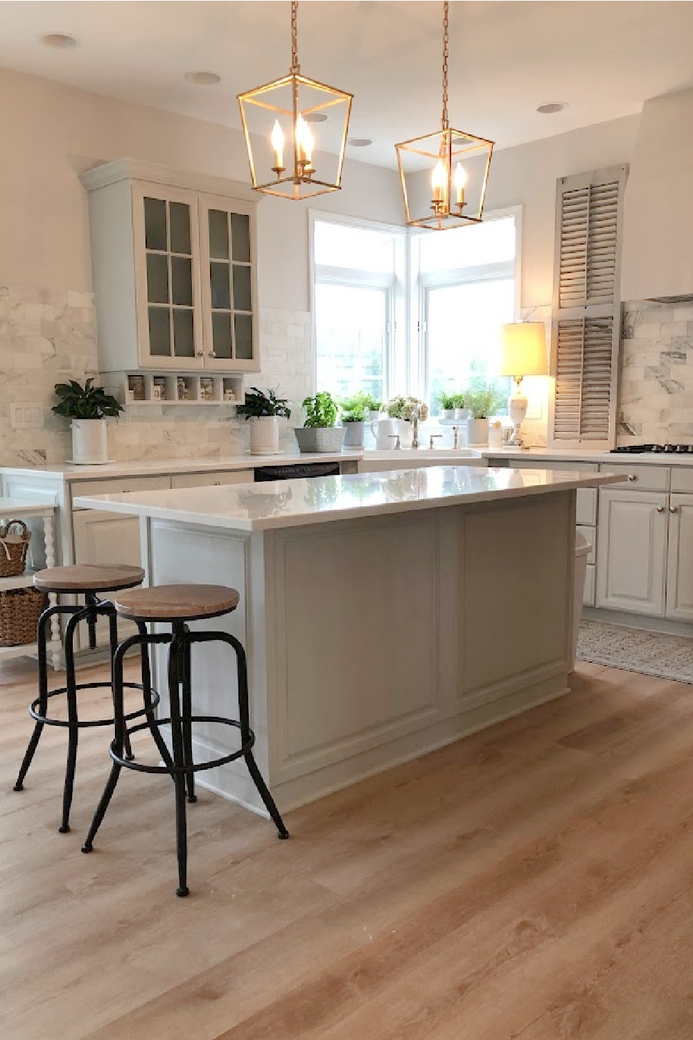 Our renovated kitchen with Viatera Muse quartz counters, calacatta gold marble backsplash, and light grey cabinets - Hello Lovely Studio.