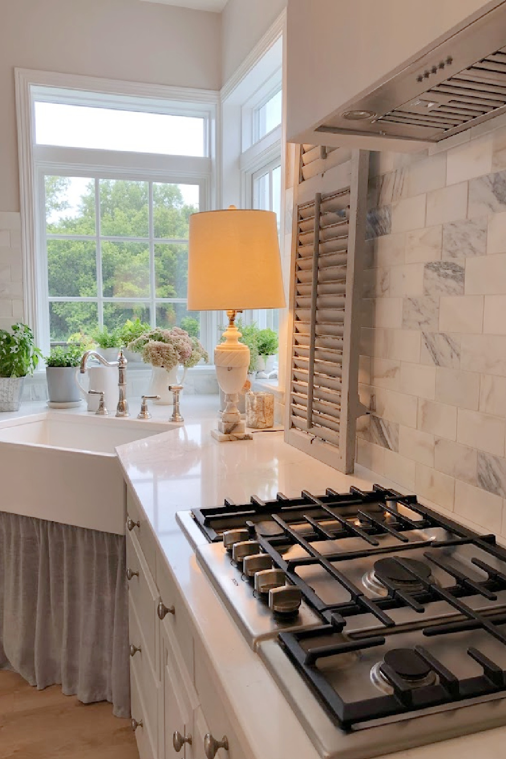 Our renovated kitchen with Viatera Muse quartz counters, calacatta gold marble backsplash, and light grey cabinets - Hello Lovely Studio.