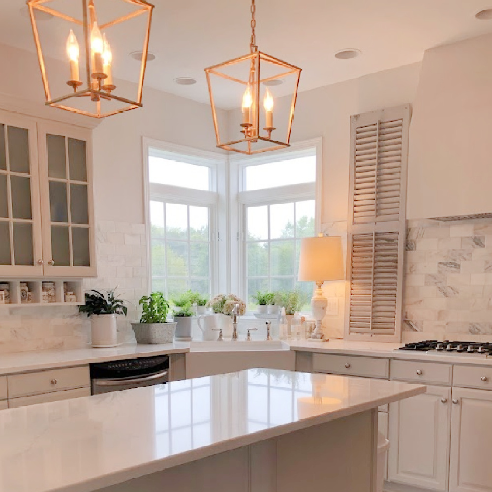 Our renovated kitchen with Viatera Muse quartz counters, calacatta gold marble backsplash, and light grey cabinets - Hello Lovely Studio.