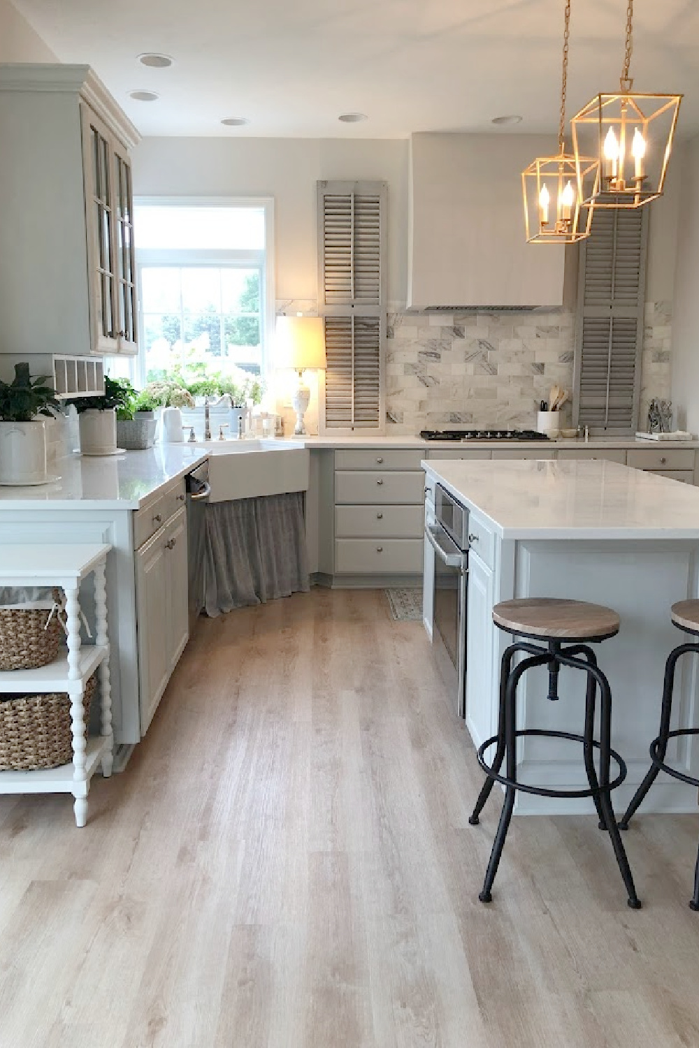 Our renovated kitchen with Viatera Muse quartz counters, calacatta gold marble backsplash, and light grey cabinets - Hello Lovely Studio.