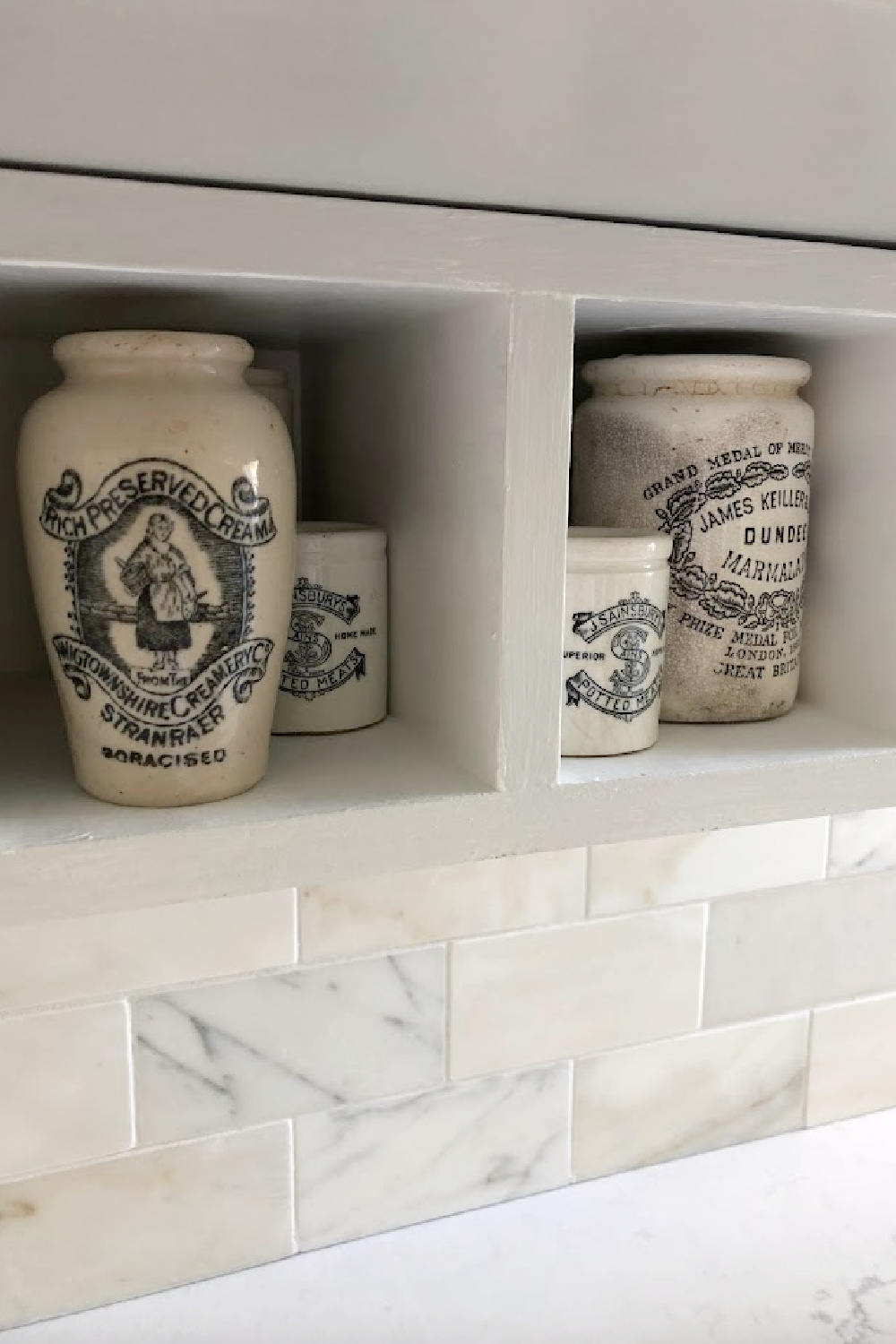 Vintage marmalade jar collection in my kitchen with calacatta gold marble tile in kitchen - Hello Lovely Studio.