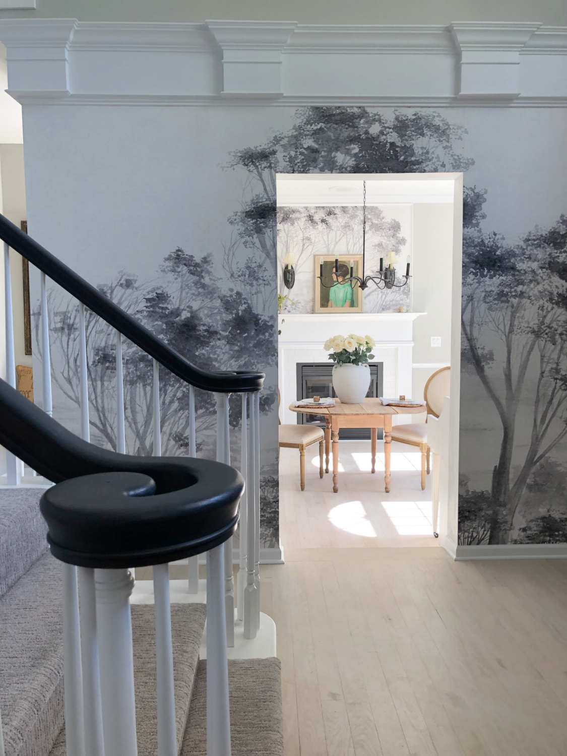 Tree mural wallpaper in our entry and dining room where we added a fireplace and refinished oak floors - Hello Lovely Studio.