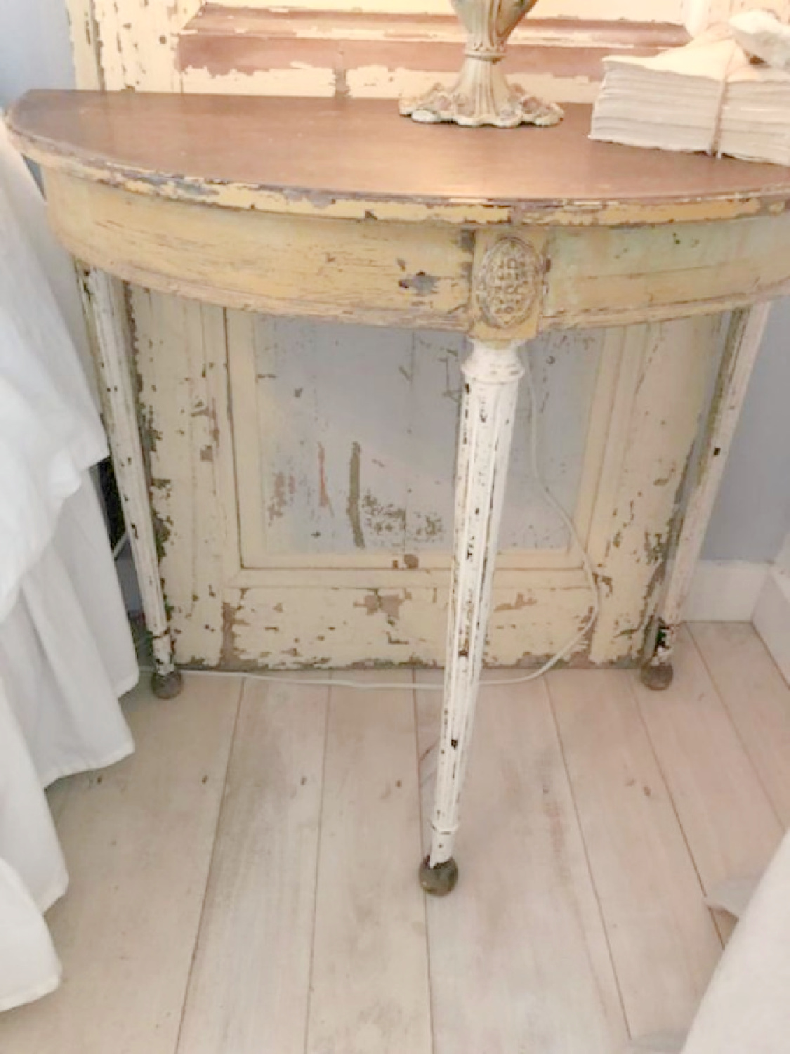 Detail of distressed vintage demilune table in rustic country cottage in Leiper's Fork, TN known as storybook cottage - Hello Lovely Studio.