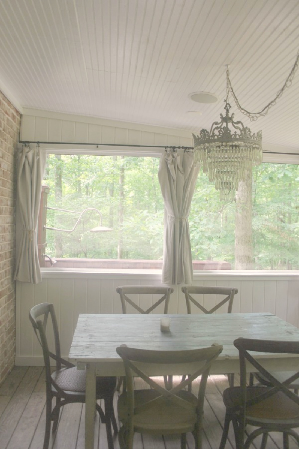 Screen porch dining area at rustic country cottage in Leiper's Fork, TN known as storybook cottage - Hello Lovely Studio.