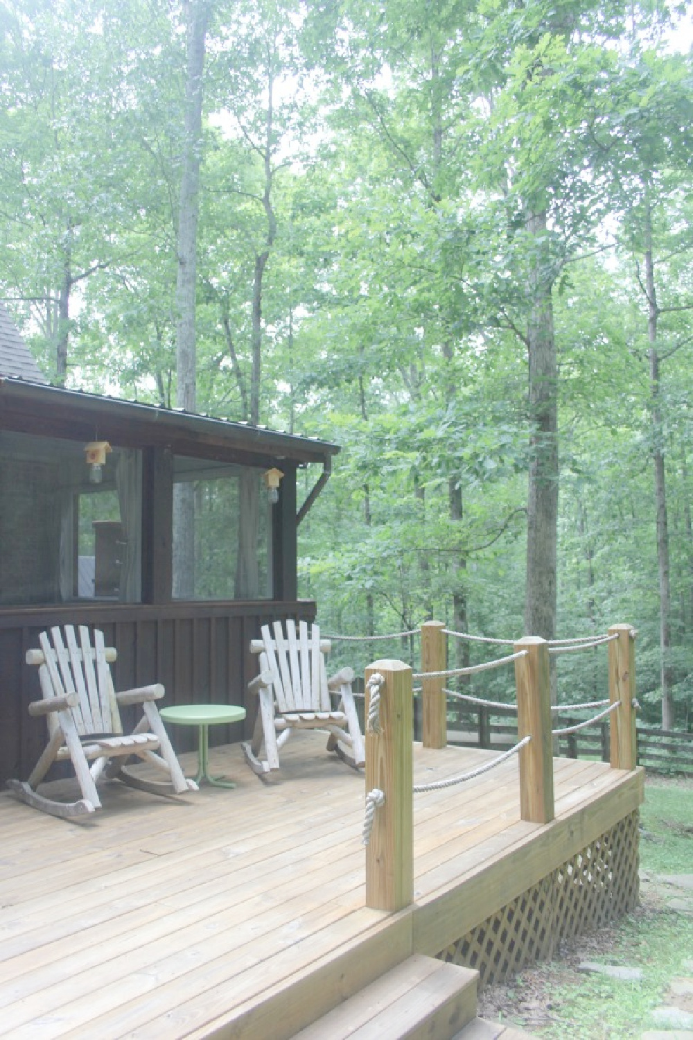 Deck with Adirondack chairs at rustic country cottage in Leiper's Fork, TN known as storybook cottage - Hello Lovely Studio.