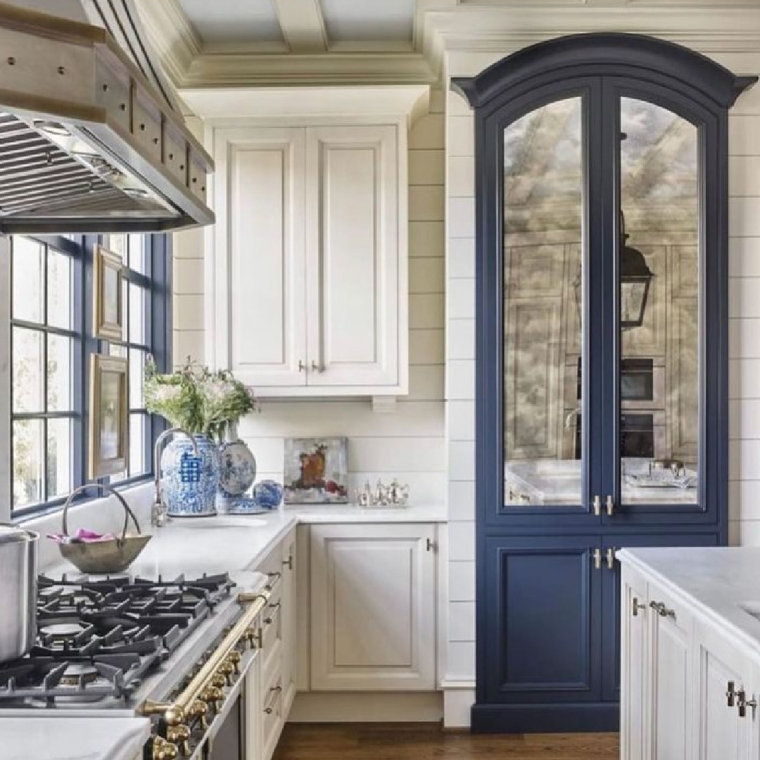 Navy blue painted arched mirrored cabinet in a gorgeous white kitchen by Matthew Quinn. #bluekitchen #navyblue #kitchendesign
