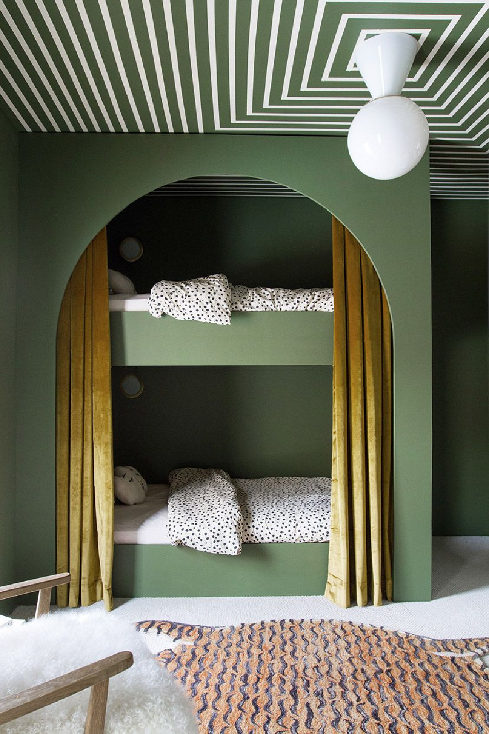 Custom bunk beds with moody deep green and, an arch, and curtains - from The Bunk Bed Book (Gibbs Smith, 2022) by Laura Fenton. #bunkbeds