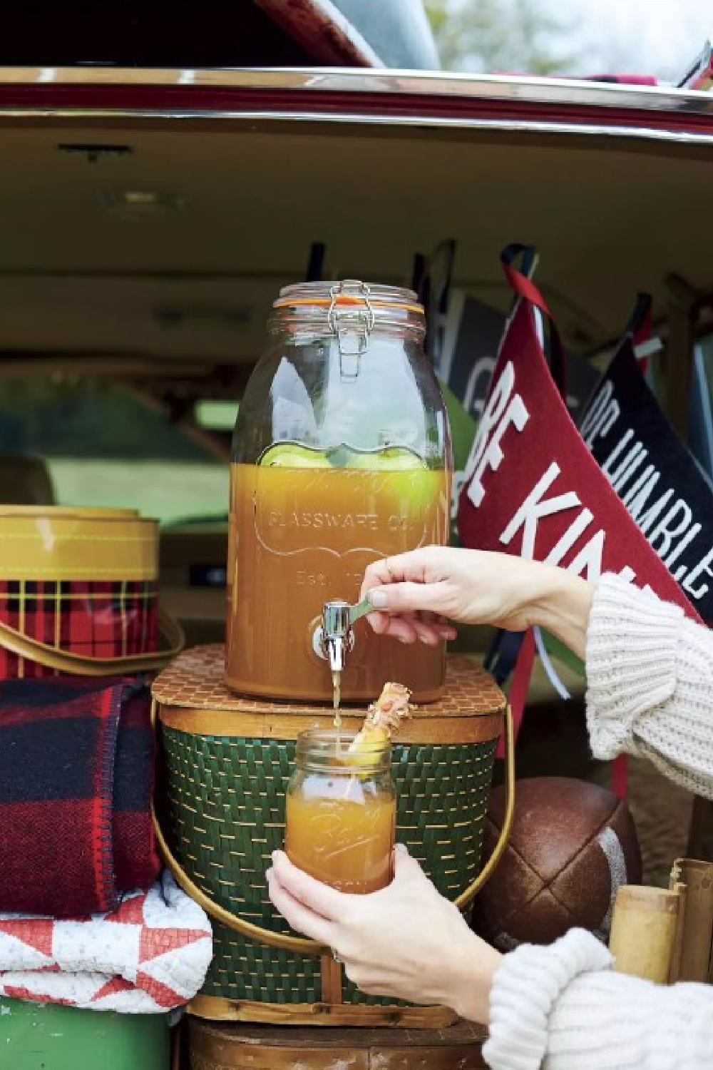 Caramel Apple Sangria served from a tailgate with vintage picnic basket - Southern Living Magazine. #caramelapples #sangriarecipes #fallsangria