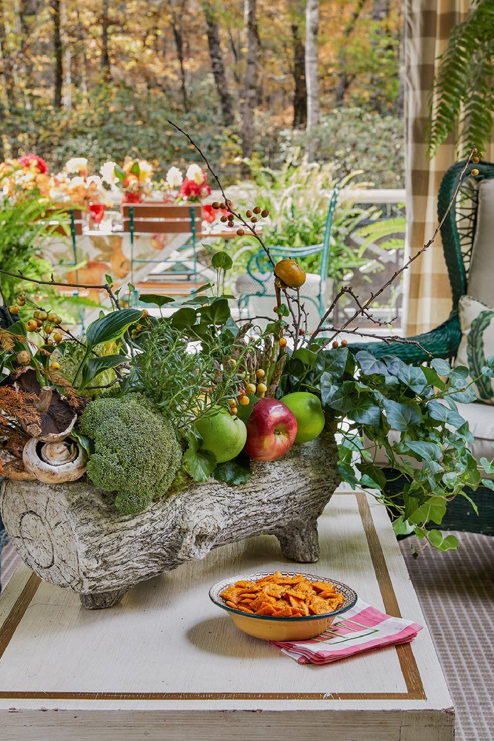 Festive holiday centerpiece in faux log planter in the charming home of James Farmer - from CELEBRATING HOME (Gibbs Smith, 2022). #holidaytable #holidaycenterpiece
