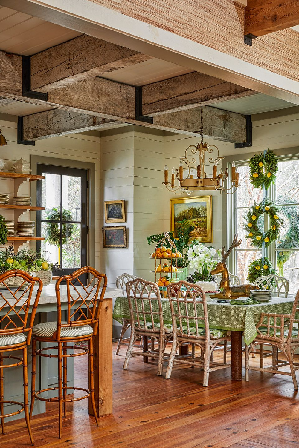 A Southern kitchen decorated festively for the holidays with fresh wreaths - from CELEBRATING HOME (Gibbs Smith, 2022). #southernhomeinterior #holidaykitchen