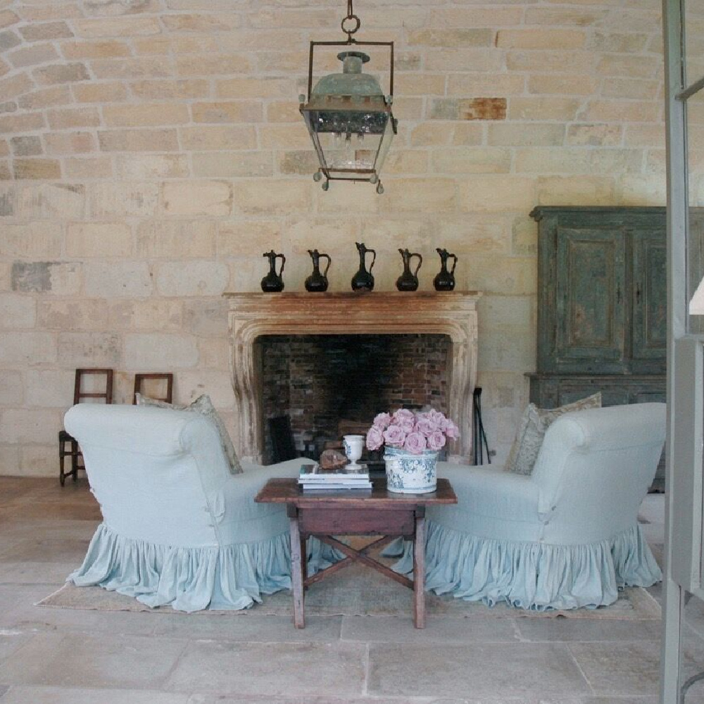 French country fireplace and slipcovered chairs in Ruth Gay's (Chateau Domingue) exquisite Houston home. #pamelapierce #frenchcountryhome
