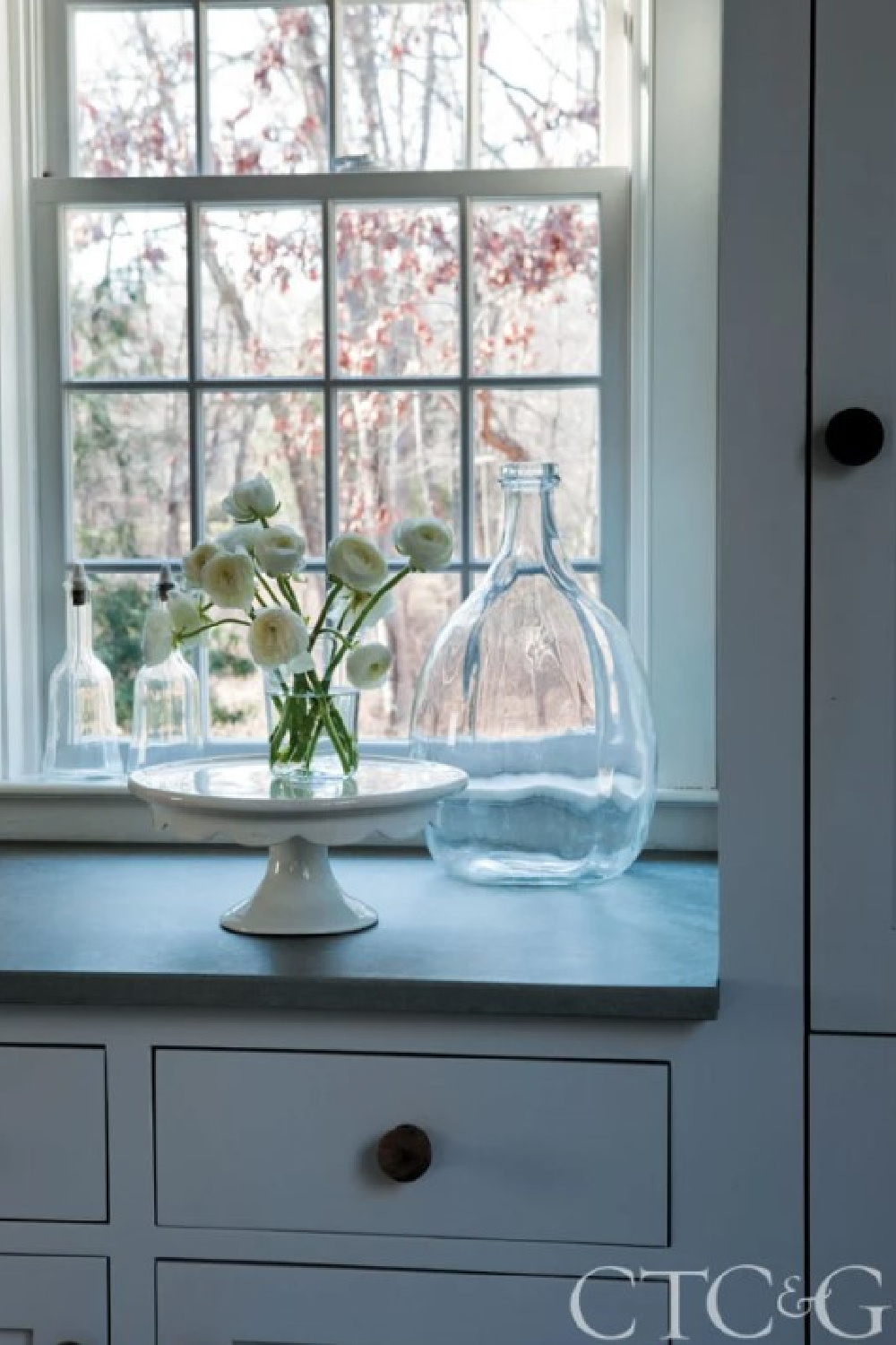 Fireslate counter with white cake pedestal and rununculus in kitchen of 1700s Connecticut cottage of Nancy Fishelson in CTCG (Feb 2012).