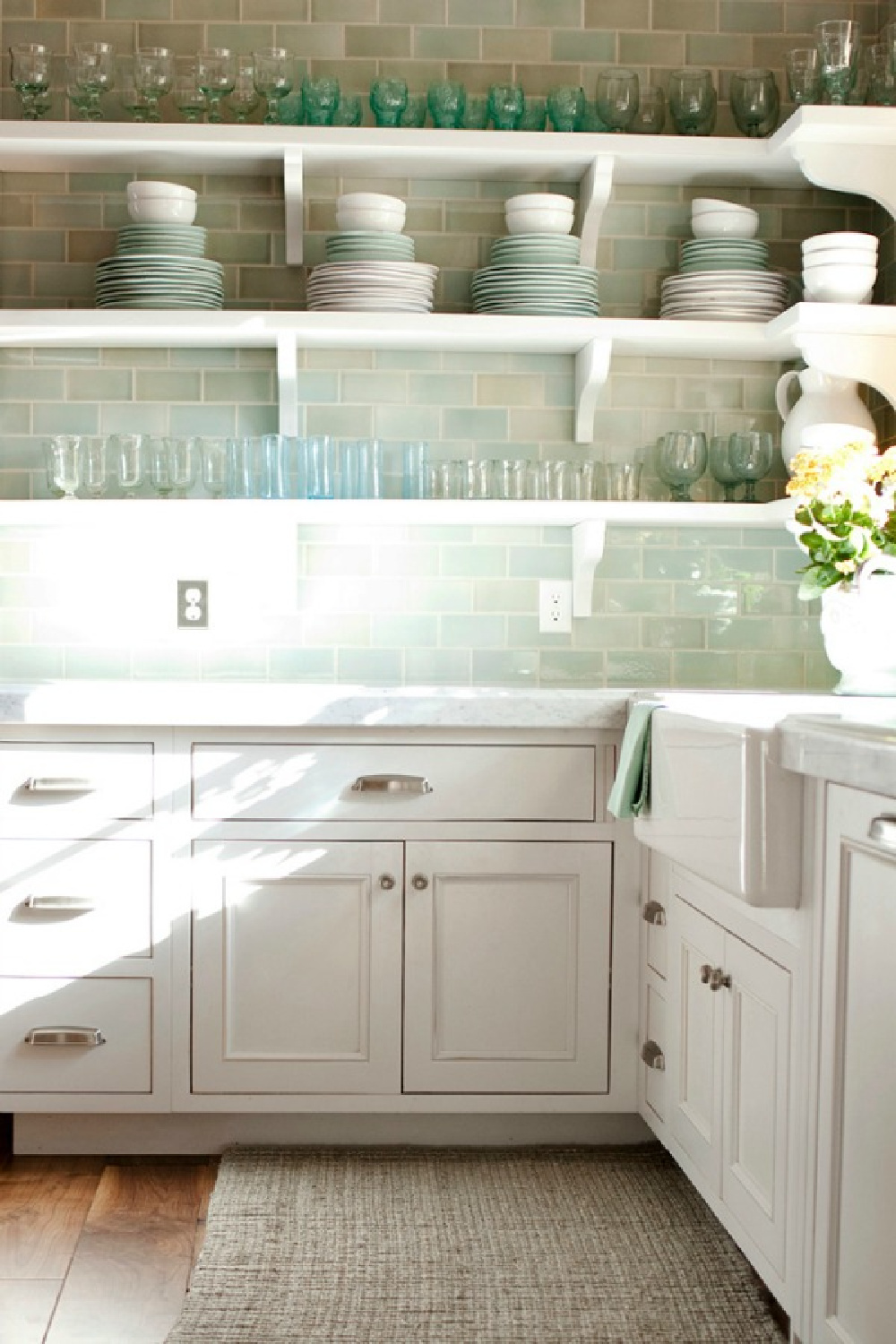 Minty green subway tile, open shelves, and white cabinetry in French country kitchen of Desiree Ashworth of Decor de Provence and Beljar Home. #greenkitchen