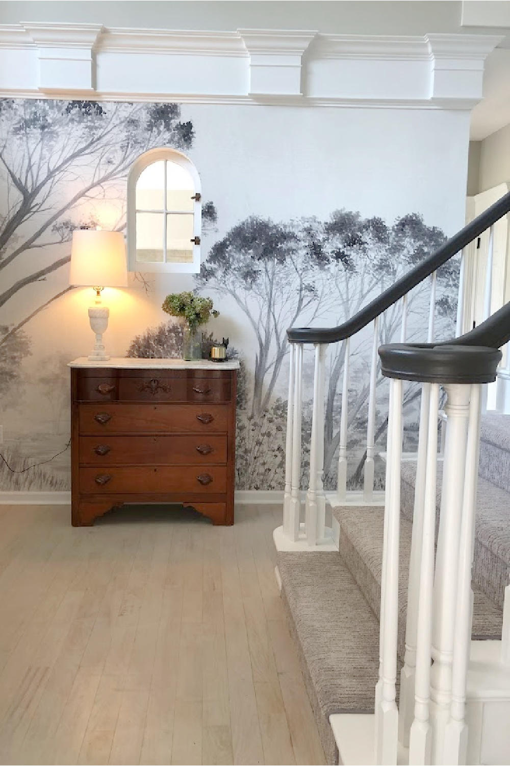 Tree mural wallpaper (Photowall) in our entry with interior arched window and marble topped chest - Hello Lovely Studio.