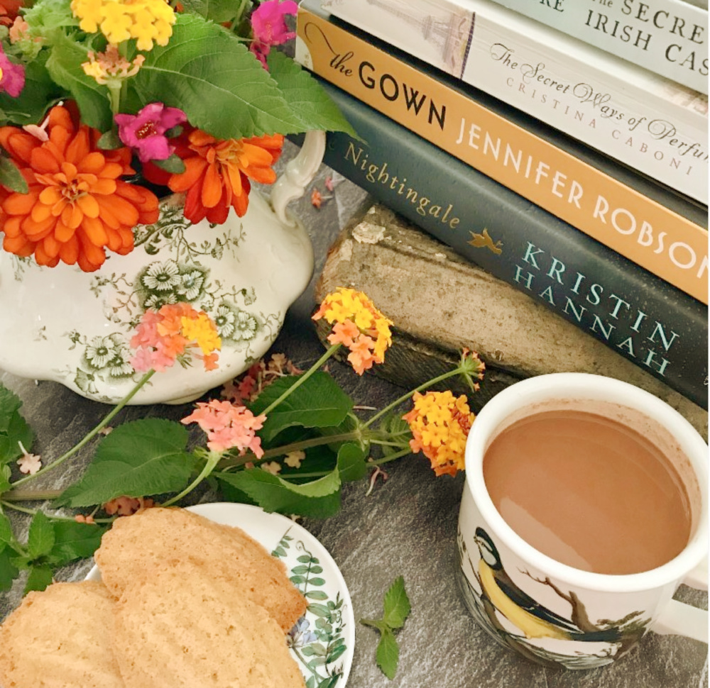 Fall vignette with a vintage feel - books, flowers, hot chocolate, and biscuits - @pineconesandacorns. #fallfeels #fallbooks