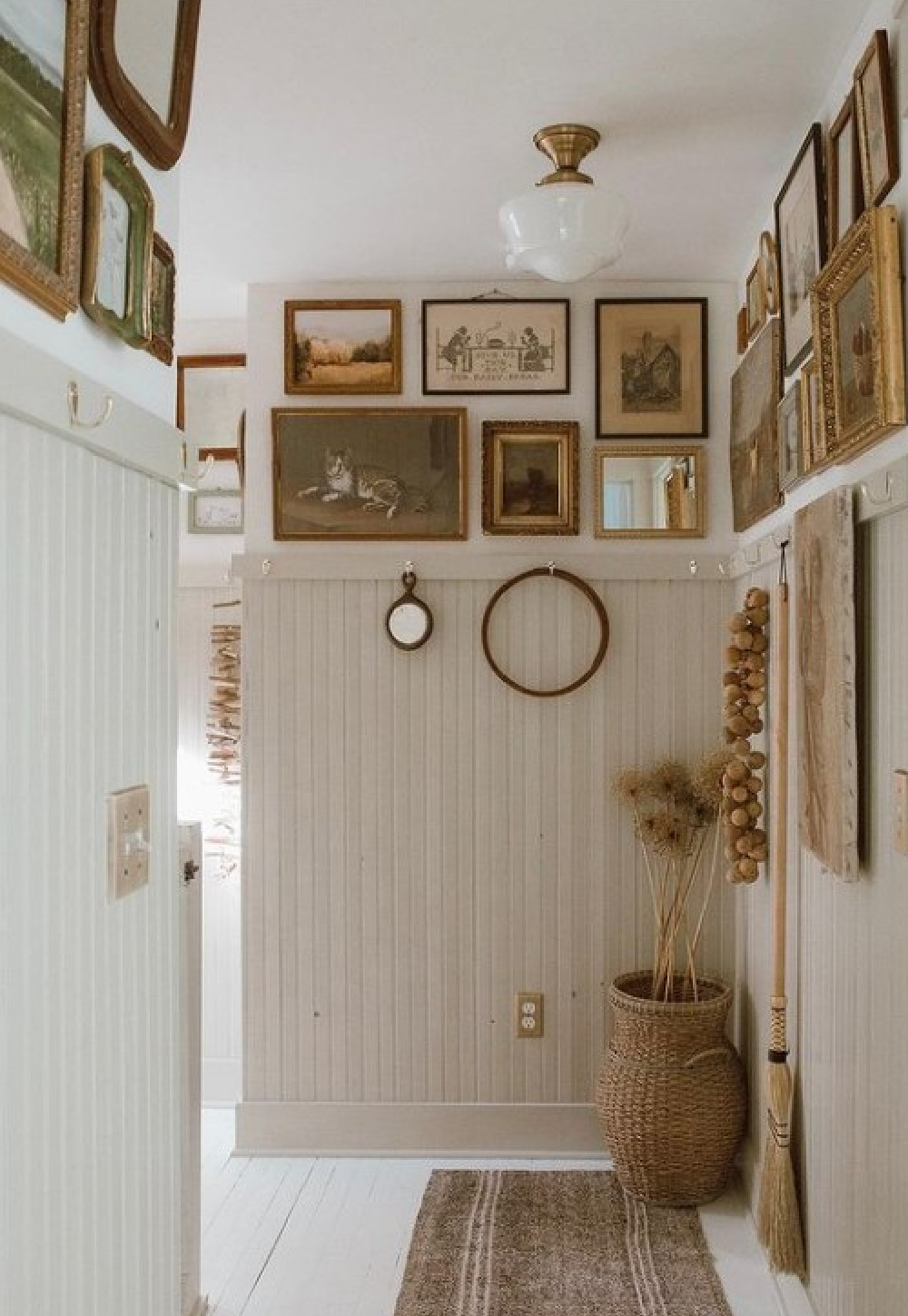 Gallery wall above beadboard with a mix of original art and prints in neutral tones - @forthehome. #gallerywall