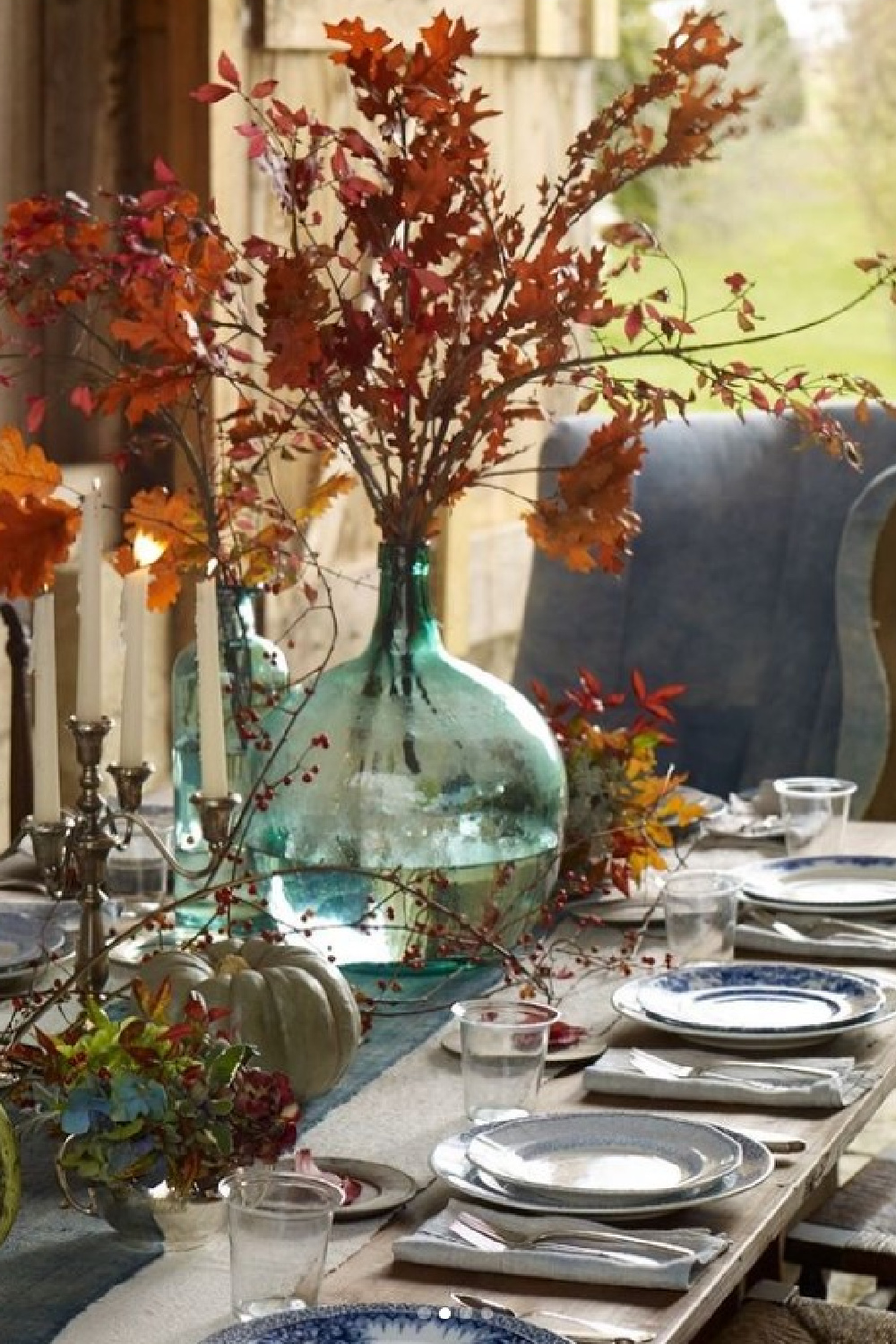 Thanksgiving tablescape with orange and blue in a lovely barn featured in Southern Living - Helen Norman. #thanksgivingtable #rustictablescape #falltablescape