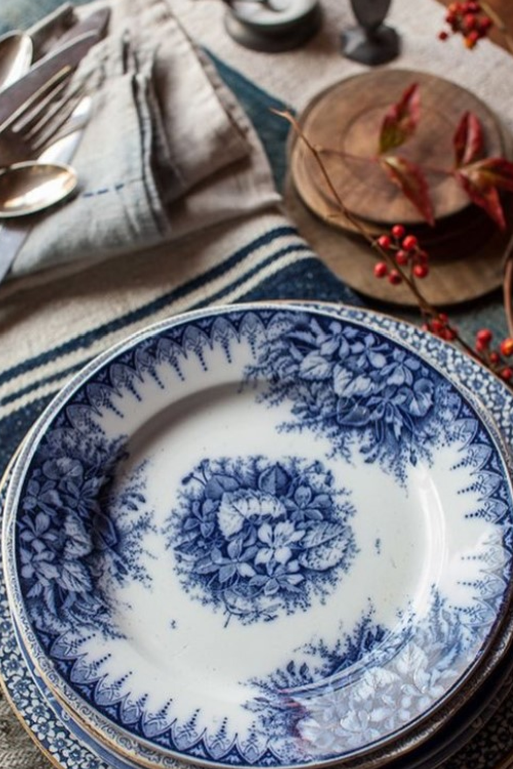 Thanksgiving tablescape with orange and blue in a lovely barn featured in Southern Living - Helen Norman. #thanksgivingtable #rustictablescape #falltablescape