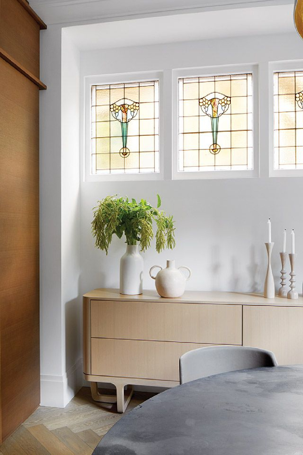 Beautiful stained glass windows and white oak buffet in a Victorian Revival home- design by Anne Hepfer in MOOD (Gibbs Smith, 2022). #earthymodern #diningroombuffet