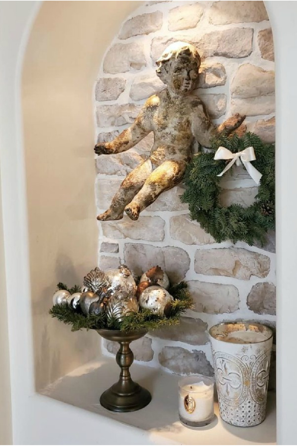 Antique cherub on stone wall holds a fresh Christmas wreath for beautiful French country Christmas style.
#frenchchristmas #christmasdecor #whitechristmasdecor