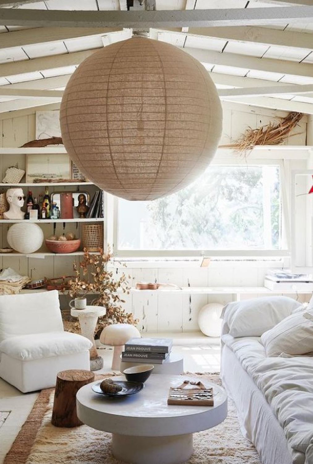 Leanne Ford designed 1920s hunting cabin living area with white furniture and paper lantern.