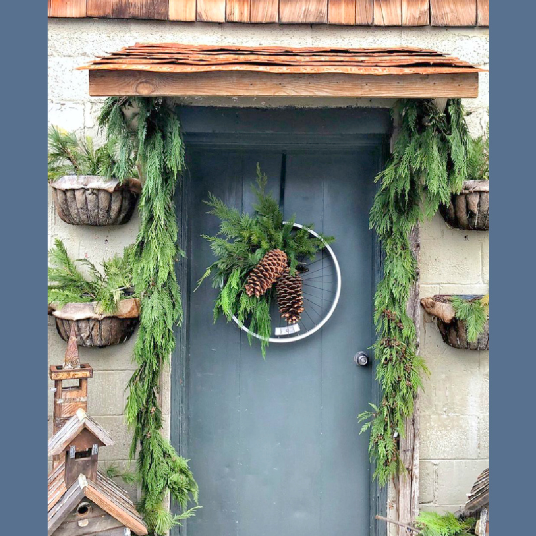 Rustic Christmas decor on a front door with bicycle wheel wreath - Brambles & Blssoms (photo by Vivi et Margot). #rusticchristmas #farmhousechristmas #hristmascottage