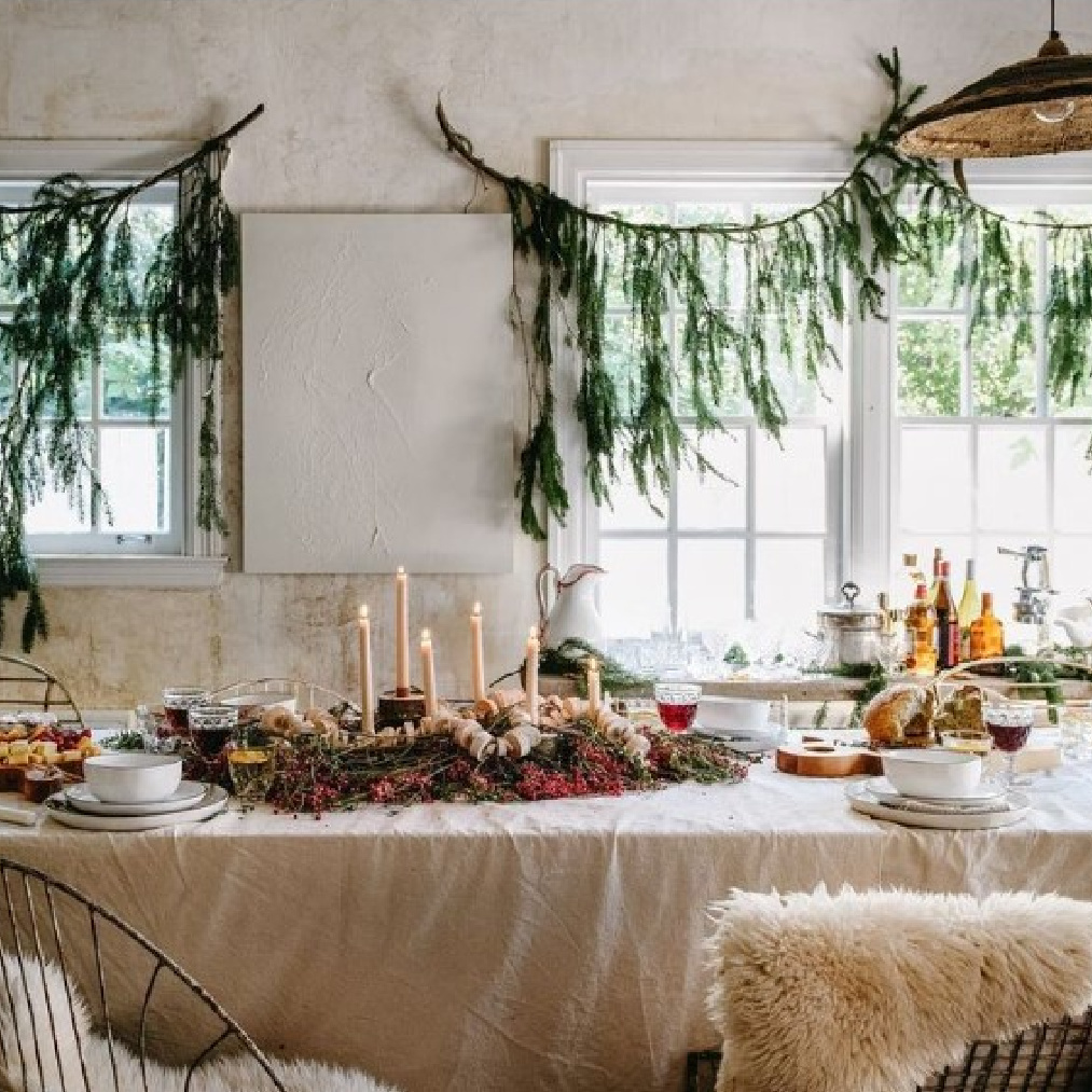 Leanne Ford's Christmas tablescape and modern rustic decor with branches swagged on windows and canvas dropcloth tablecloth. #leanneford #rustictablescape