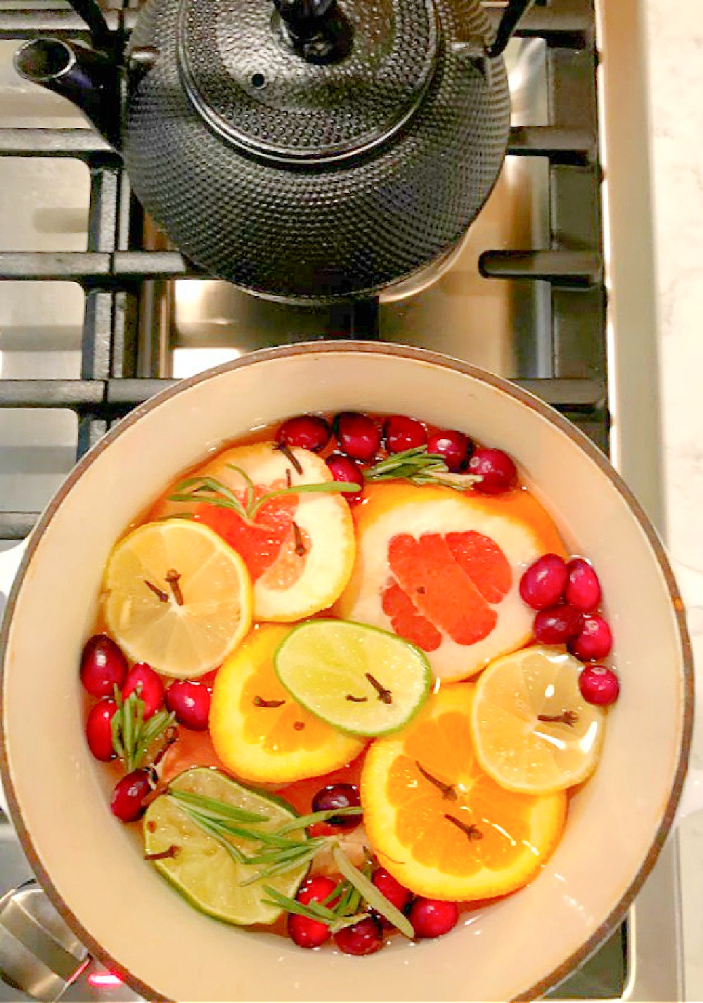 Vividly colorful citrus simmer on the stovetop fragrances the house with grapefruit, rosemary, and fall spices - Hello Lovely Studio.