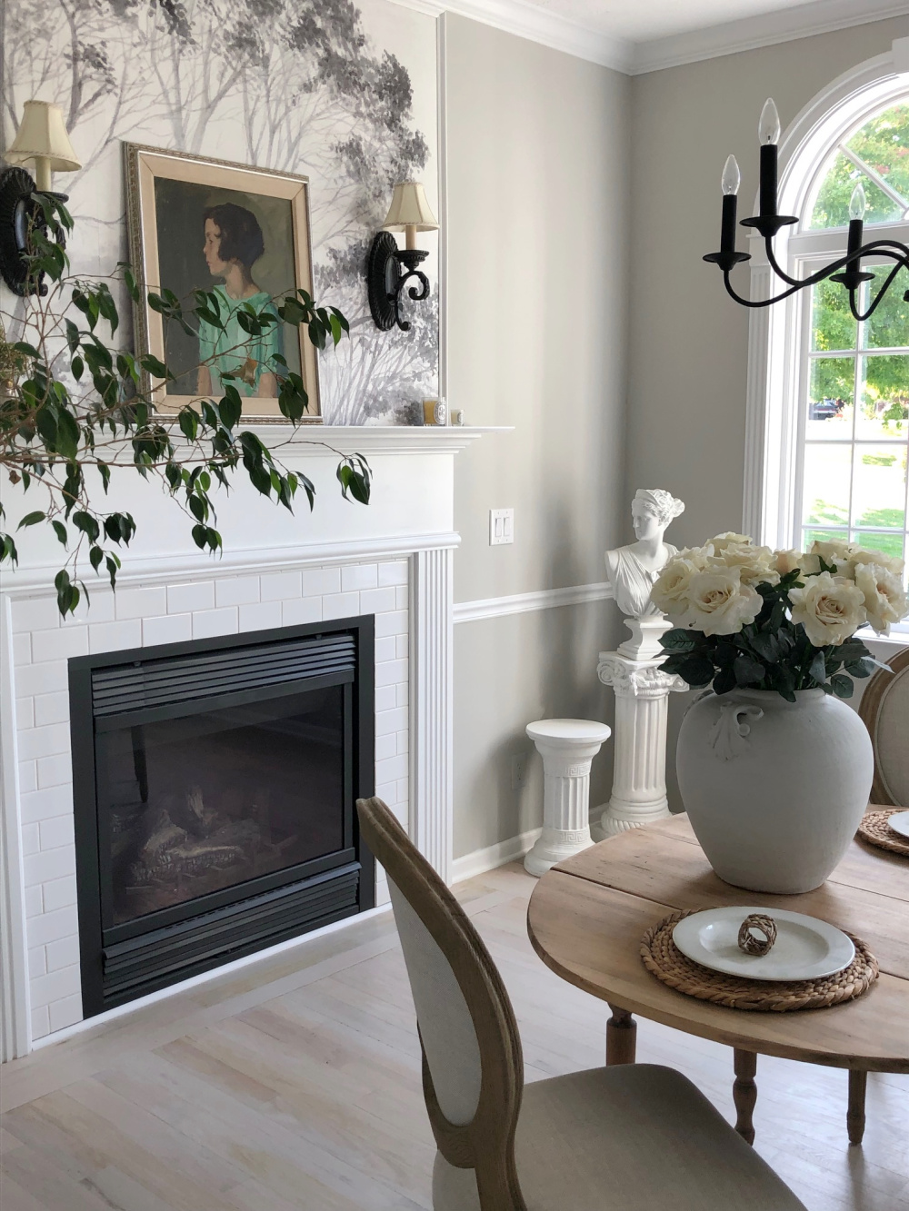 Hello Lovely's modern French dining room with antiques, oil portrait, and fireplace.
