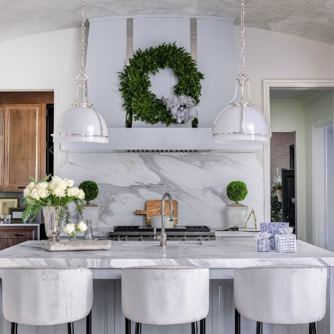 Elegant icy blue kitchen with range hood decorated with wreath in Atlanta Holiday Home - @janegroupinc design. #atlantaholidayhome #bluekitchens #christmaskitchens