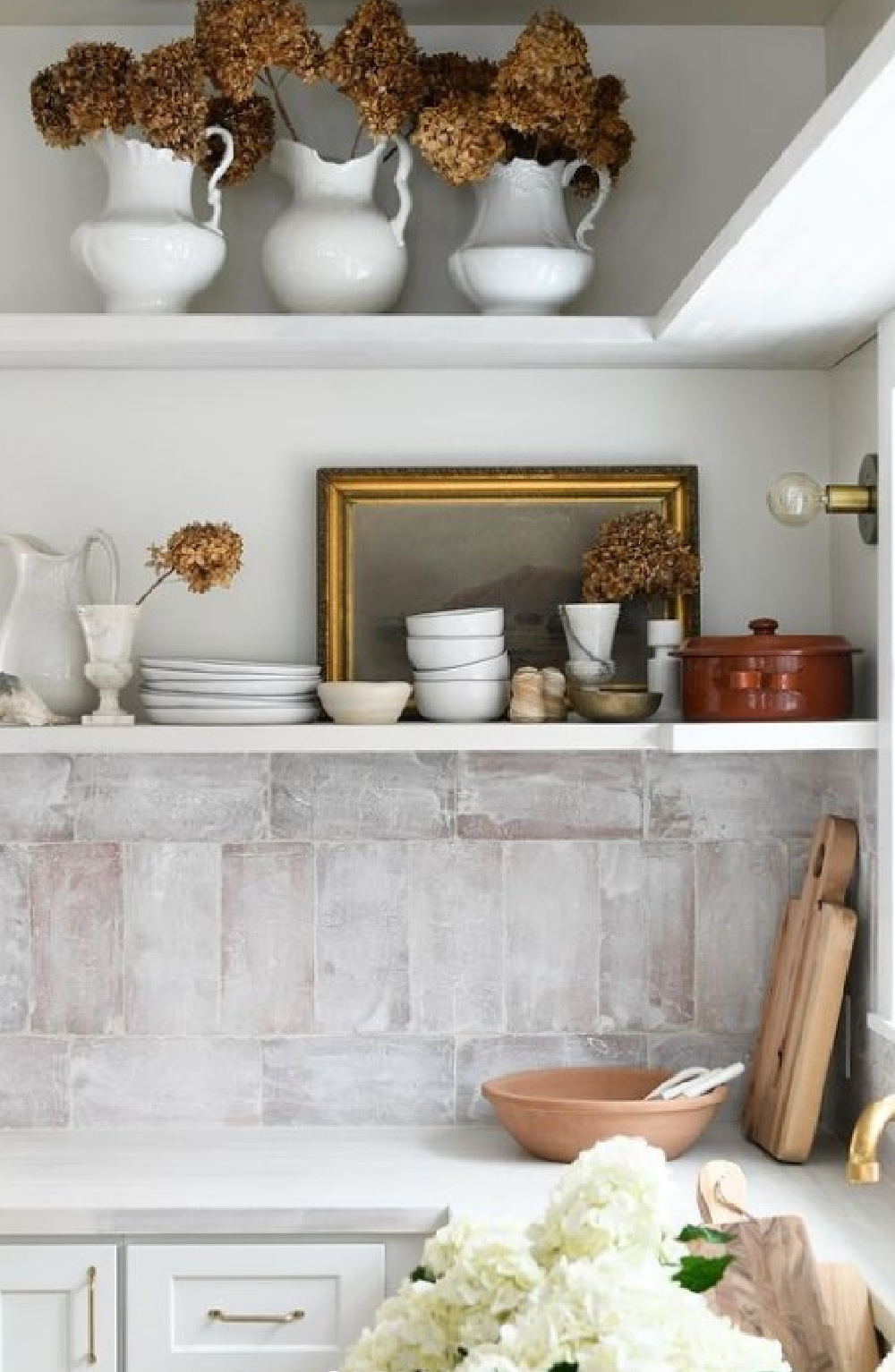 Leanne Ford designed rustic modern kitchen with white shelves, farm sink, and customized tile backsplash. #leanneford #modernrustic