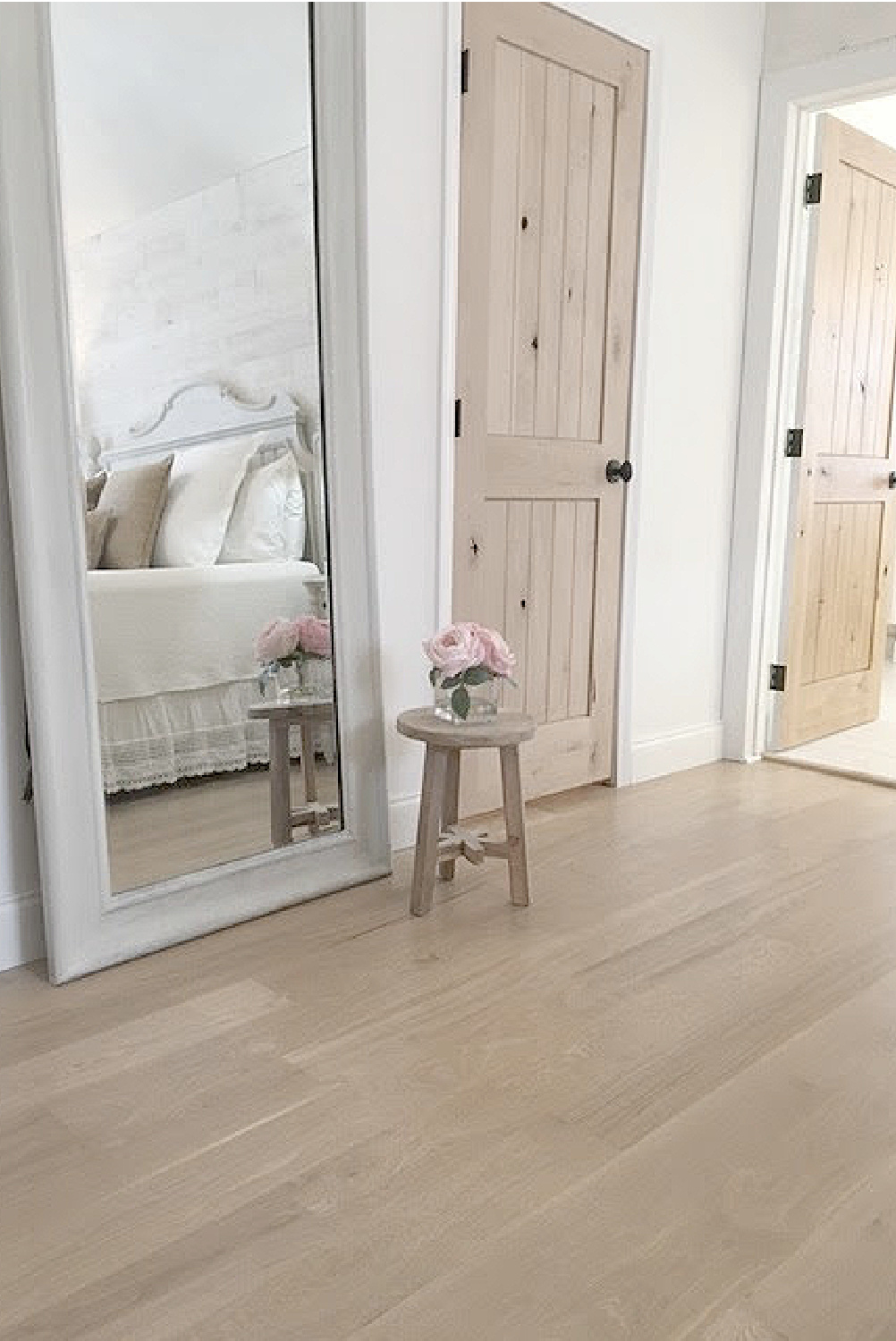 Knotty alder doors, white oak flooring, and neutral decor in a serene European country bedroom - Hello Lovely Studio. #europeancountry #knottyalder #serenebedroom
