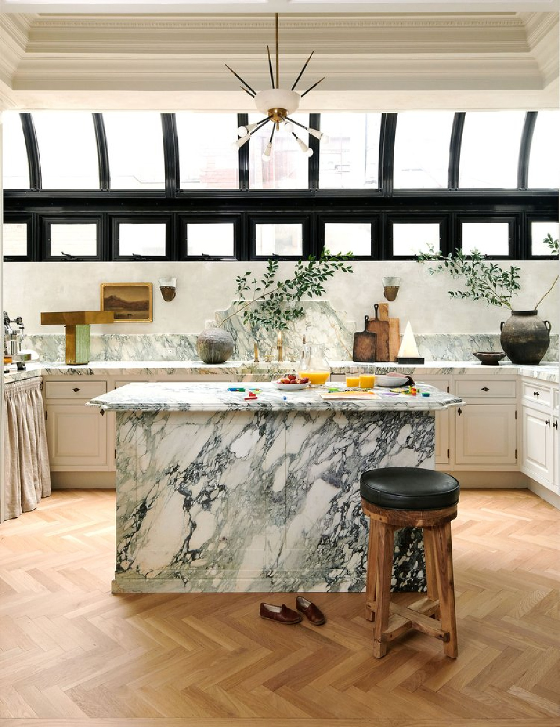 Nate Berkus Jeremiah Brent Manhattan kitchen with black greenhouse-like windows, Calacatta Paonazzo marble counters, white cabinets, and creamy plaster walls - in AD (photo by Kelly Marshall).