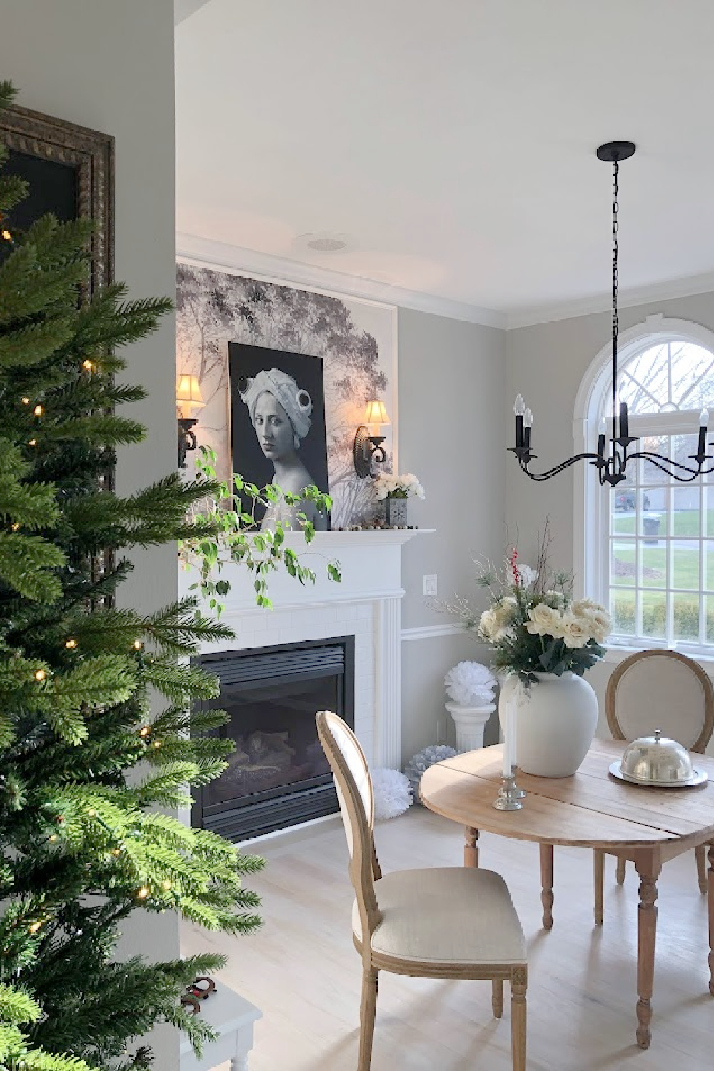 Christmas tree (Belgian Fir) near the dining room with fireplace, arched windows, and oval antique table with Louis style chairs - Hello Lovely Studio.